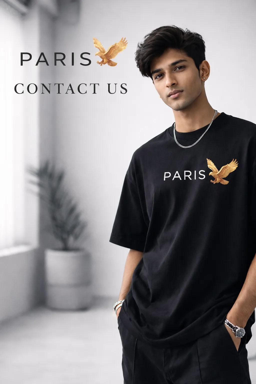 Young Indian male model wearing black oversized streetwear T-shirt with small Paris Eagle logo on chest